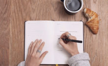 Imagem de uma mulher a definir objetivos para o novo ano e a escrevê-los num planner
